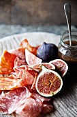 A salami platter with figs and a honey-balsamic sauce