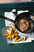 Steak in a pan with chips