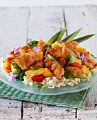 Sweet and sour chicken with peppers and baby corn on a bed of rice (Asia)