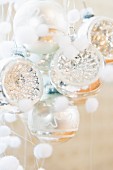 Silver Christmas baubles and small fluffy balls representing snowflakes