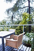 Wicker chair and table on snowy wooden terrace