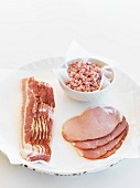 Rashers and slices of bacon and diced bacon on parchment paper