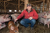 A farmer in a pig pen