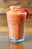 A peach smoothie made with apple juice, oranges and strawberries