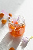 A jar of kumquat jam with a spoon