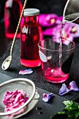Hibiskusblütensirup zubereiten (Wasserglas, Sirupflasche, Hibiskusblüten)