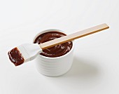 Barbecue sauce in a bowl with a brush