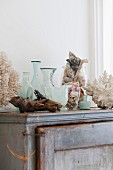 Vasen, Glasbehälter und Fundstücke aus dem Meer auf altem Schrank im Badezimmer