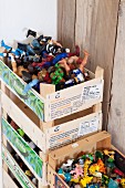 Colourful toys in stacked fruit crates against board wall