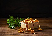 Fresh chanterelle mushrooms in a wooden basket with parsley