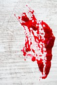 A red jam stain on white wood