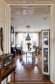 View through open double doors into traditional-style interior with modern dining set