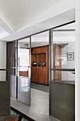 Glass and metal partition with door leading to hallway