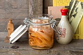 Sweet-and-sour pickled ginger in a flip-top jar on a wooden shelf