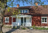 Schweisches Holzhaus mit weisser Veranda am Eingang