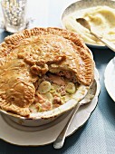 Salmon pie with bacon, quail's eggs and leek served with mashed potatoes (England)