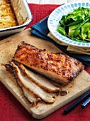 Slow-roasted pork belly with an orange glaze and a side salad
