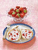 Wafer cones filled with cream and strawberries with icing sugar