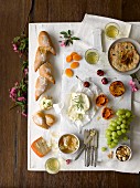 Vorspeisenplatte mit gegrillten Pfirsichen, Aprikosen, Kirschen, Trauben, Nüssen, Honigwabe, Brot und Weißwein