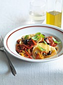 Pansotti alla genovese (pasta parcels with tomatoes, peppers and capers, Italy)