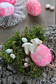 Easter arrangement of bark, moss, sugar eggs and china lamb