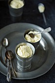 Vanilla ice cream in pewter cups with silver spoons