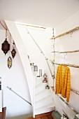 Oriental lanterns on narrow staircase and DIY clothes rack made of branches