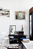 White-painted wooden chair and black shelves in vintage interior