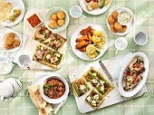 A picnic featuring rice balls, spicy chicken wings, fish balls, ratatouille, ribs, vegetable tart, unleavened bread and falafel