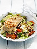 Orzo salad with fresh vegetables and grilled chicken breast