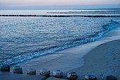 Buhnen als Wellenbrecher am Strand von Ahrenshoop an der Ostsee, Abenddämmerung