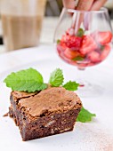 A chocolate brownie with marinated strawberries