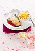 Salmon fillet in parchment paper with lemon, tomatoes and tagliatelle
