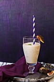 A fig shake in a glass with a straw