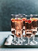 Mehrere Gläser Rosé-Himbeer- Minz-Fizz auf Blechtablett