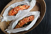 Raw salmon fillets in paper with ginger and chilli