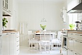 View from Scandinavian, fitted kitchen with two counters to white, shabby-chic dining area