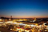 A few over the illuminated Djemaa el-Fna market square at sunset in Marrakesh, Morocco