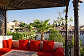 Red cushions on the roof terrace of the Riad Dar Doukkala Hotel in Marrakesh, Morocco invite you to linger