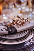 Festive place setting with linen napkin and golden twig