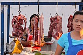 Zwei Frauen am Fleischstand auf dem Markt, Thailand