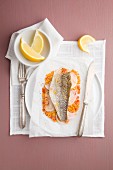 Sea bass on a bed of couscous and onions in parchment paper