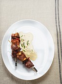Veal skewers with onions, chorizo and cheese sauce with chives