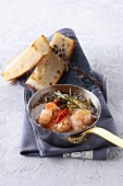 Prawns with chilli peppers in a pan served with white bread