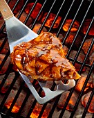 Chicken breast on a spatula on a barbecue