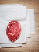 Raw ox steak on a piece of white paper