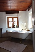 Free-standing bathtub below window in renovated bathroom