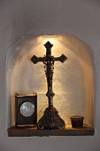 Crucifix and table clock in illuminated niche