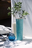 Olive branch in turquoise vase, glass tealight holders and large pillar candle