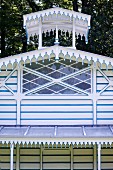 Blau-weiss gestreifter Gartenpavillon mit rautenförmigen Fenstersprossen und orientalisch anmutenden Dachverzierungen